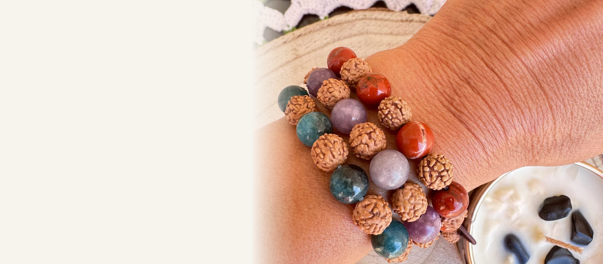 Tres pulseras de rudraksha y piedras naturales en la muñeca
